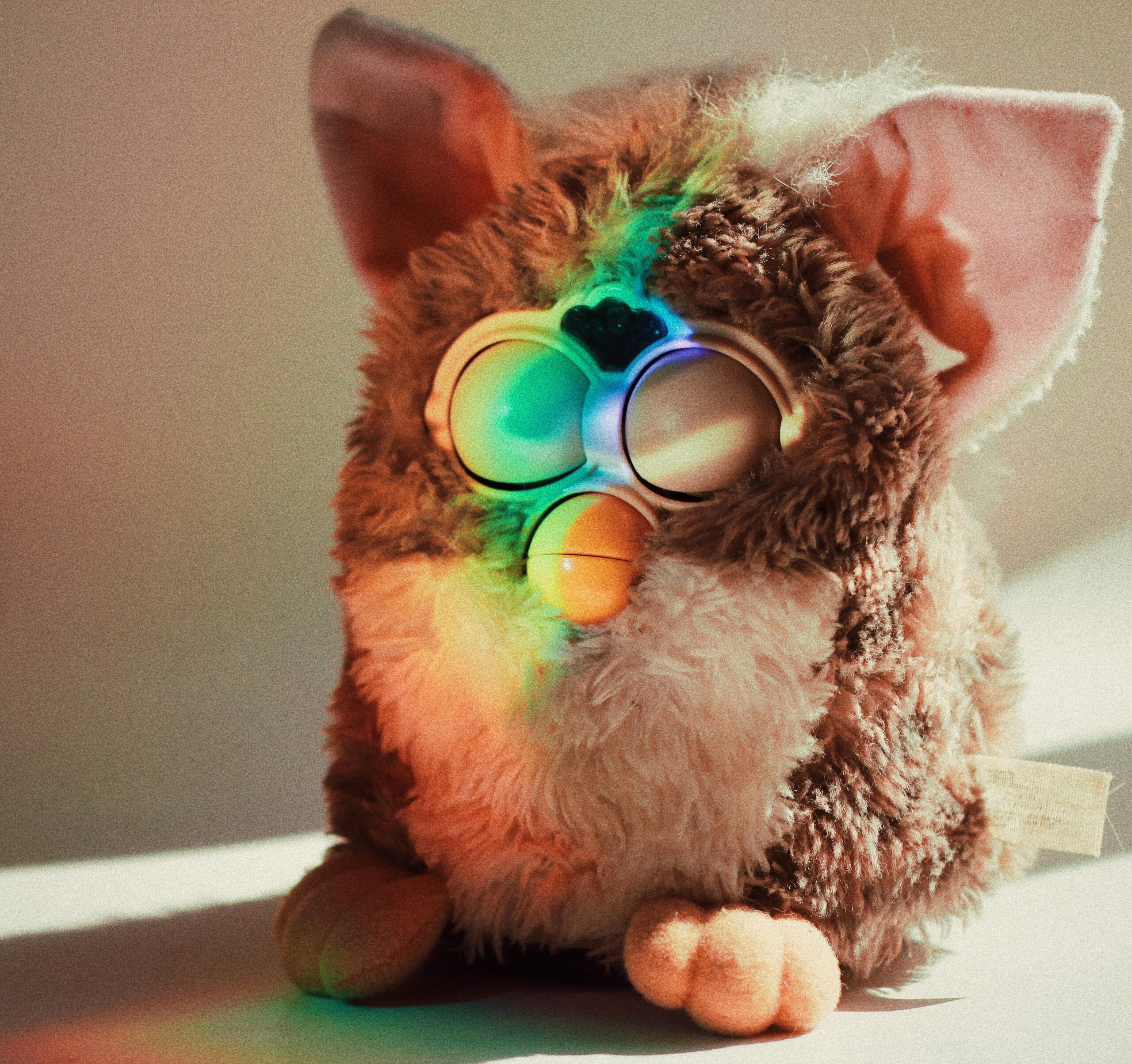 A vintage fluffy toy with a rainbow reflection indoors, highlighting its unique features.